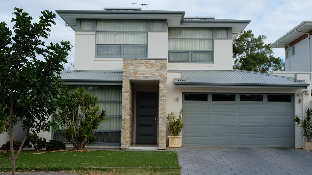 Front of a modern two-storey home with a double garage and landscaped entry