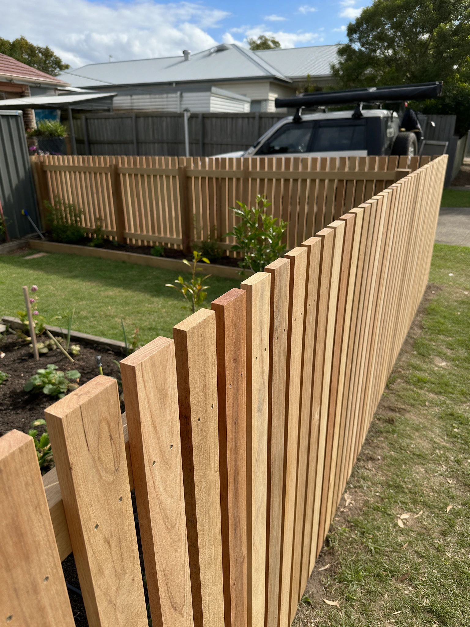 Timber paling fence line beside a suburban home